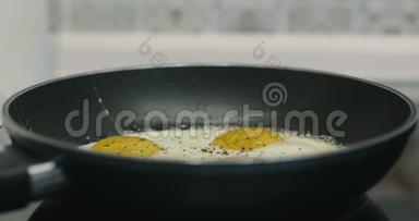 在黑金属锅里煮四个煎蛋. 煎锅中四个鸡蛋的早餐食品准备。 电影院4K